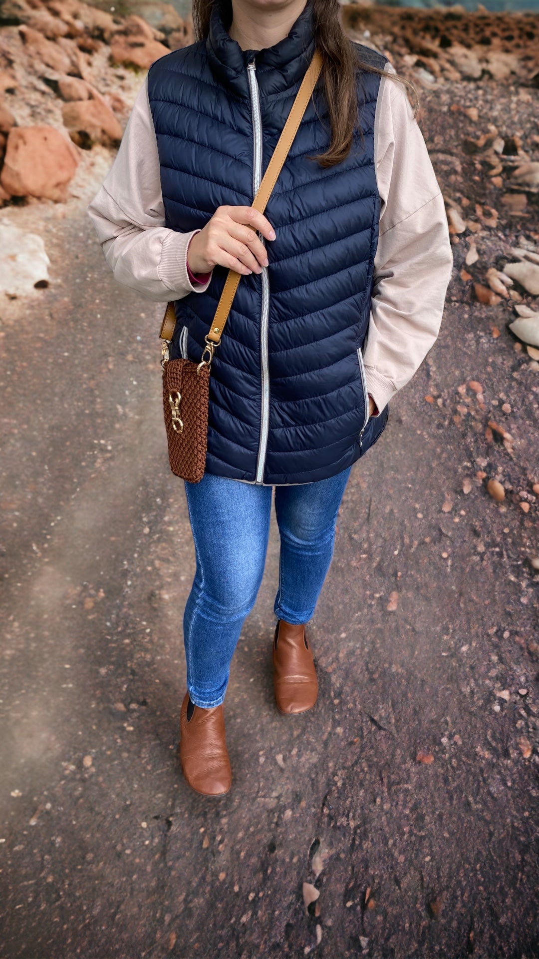 women wearing brown handmade phone case on  a long eco leather strap. case has a luxury look and it closes with golden hook which is attached to crocheted strap